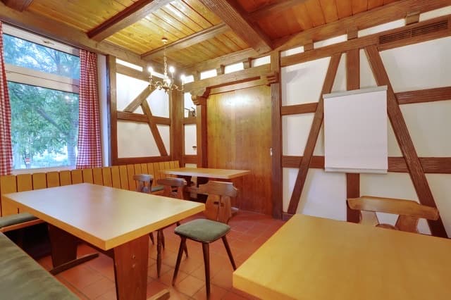 Gastraum mit Fenster, Tischen und Flipchart, Tageslicht